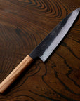 Chef's knife with a wooden handle on a wooden surface
