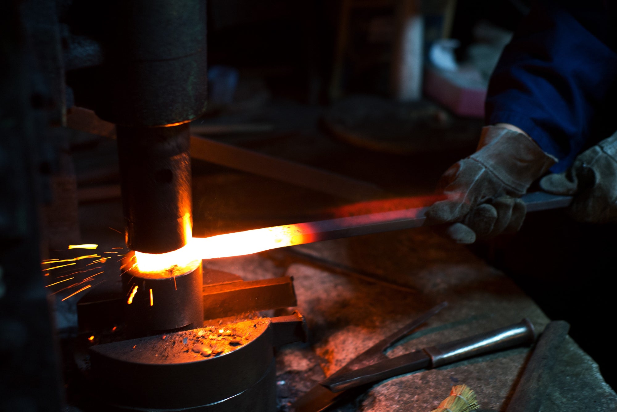 using a hammer to forge a knife blade