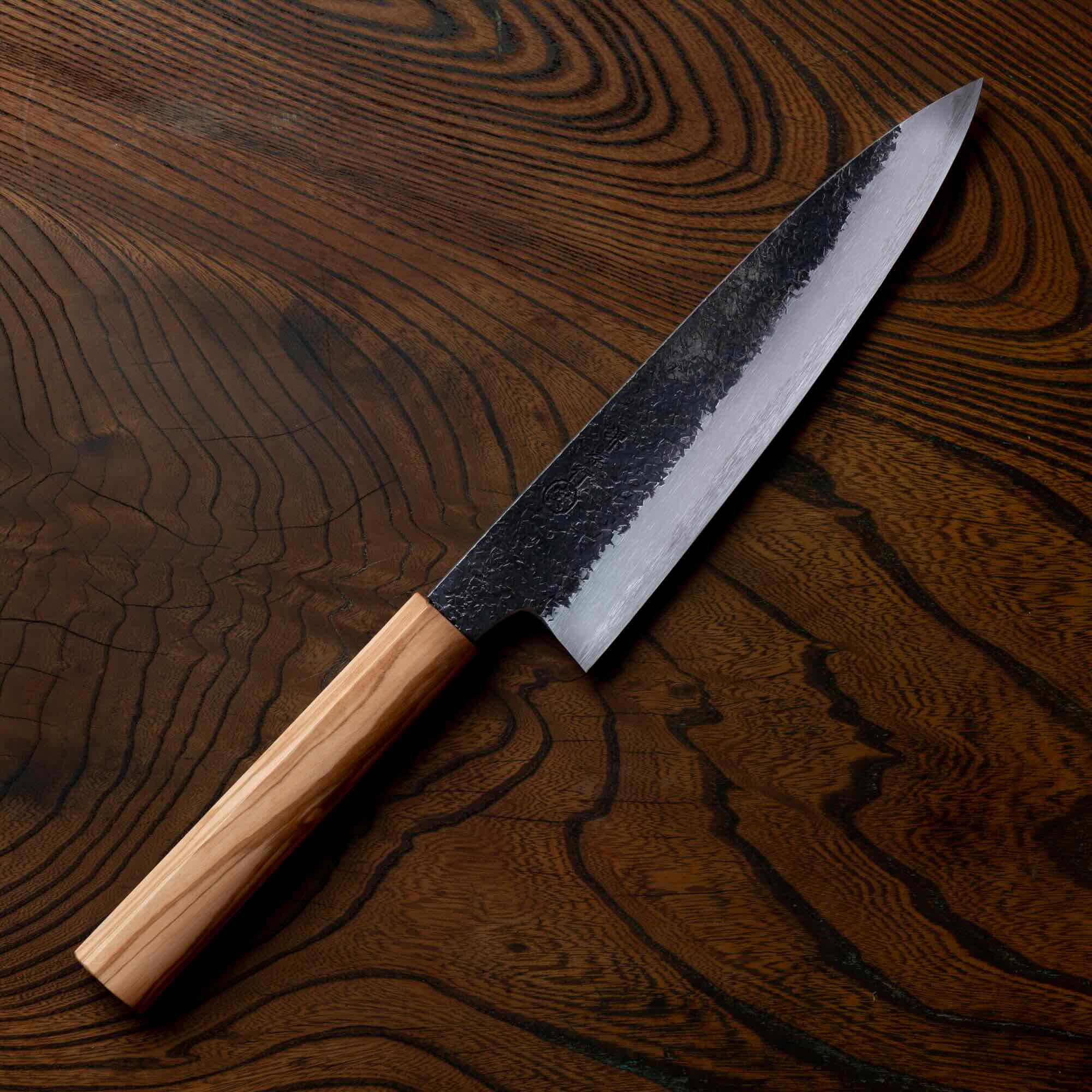 Chef's knife with a wooden handle on a wooden surface