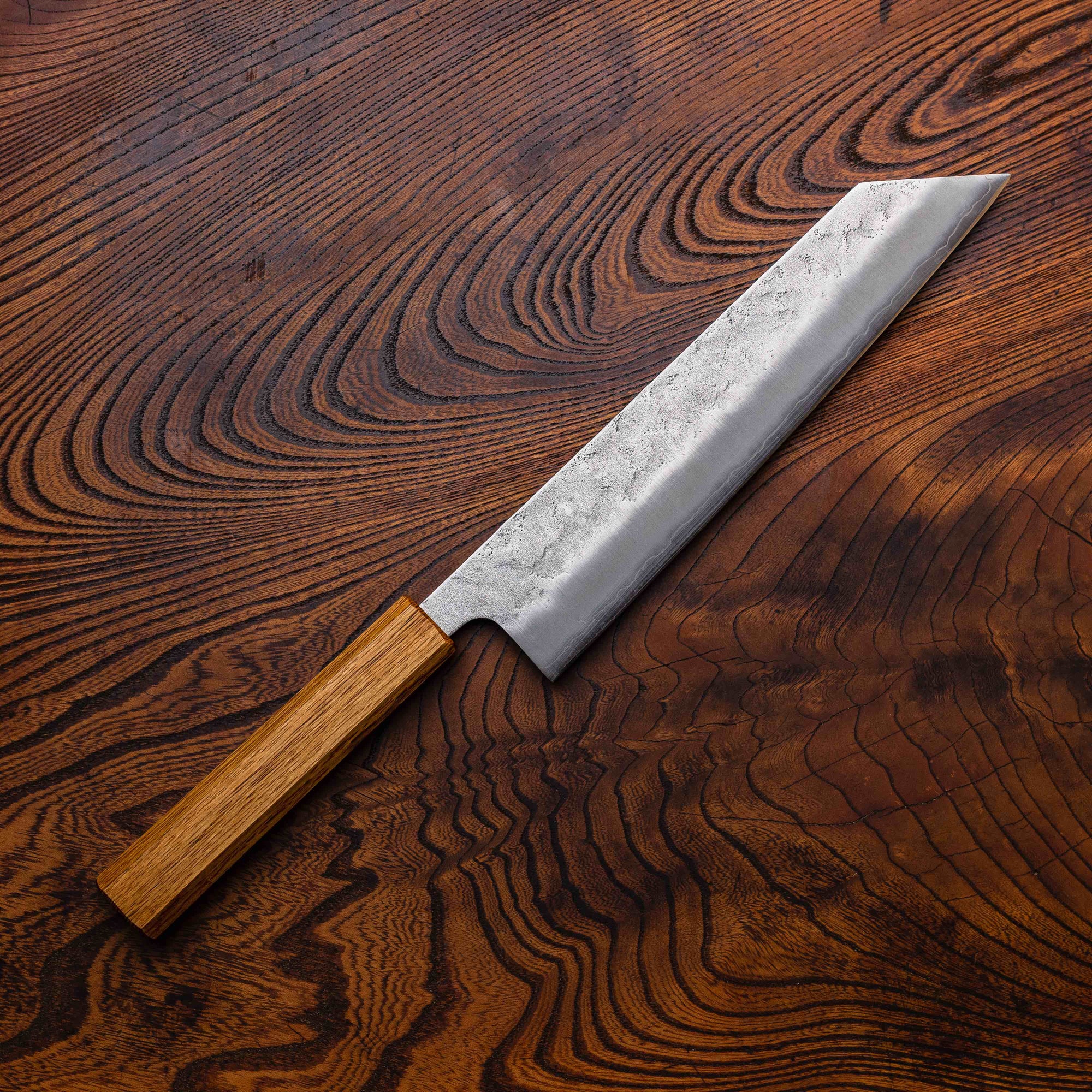 Chef's knife with wooden handle on a wooden surface